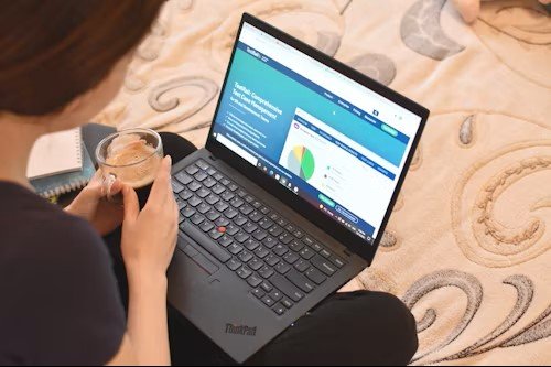 Canadian consumer checking their credit score on a laptop with financial documents on the table