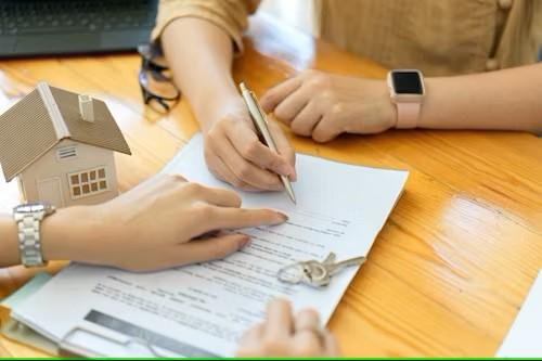 Canadian co-signer and homebuyer reviewing mortgage documents together before signing