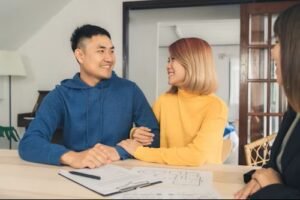 Young first-time homebuyers in Canada holding house keys and reviewing mortgage documents
