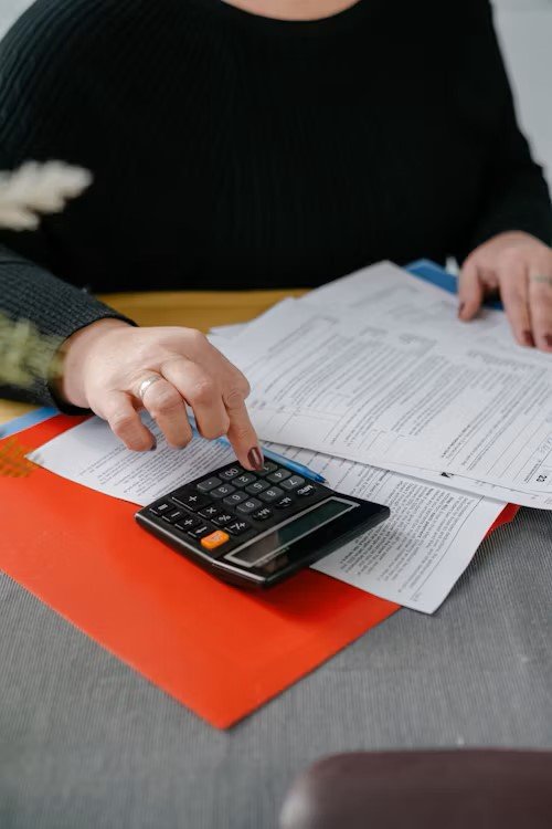 Canadian mortgage paperwork with calculator and tax forms showing PST on insurance