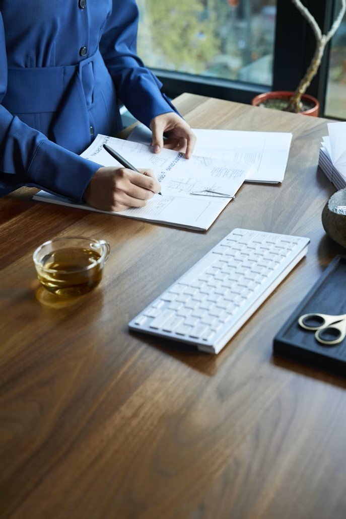 "A Canadian couple at their kitchen table reviewing mortgage documents labeled fixed, variable, and hybrid, with a laptop showing interest rate charts.