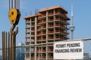 “Toronto condo construction slows—crane hook in foreground and half-built tower behind, illustrating CMHC warning on stalled housing starts.”